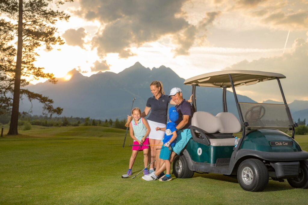 Rodina na golfovom ihrisku pri golfovom vozíku