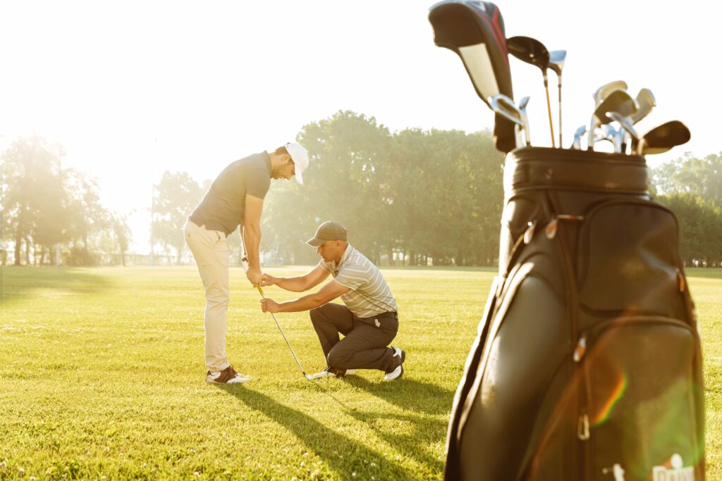personal trainer giving lesson young male golfer (1)